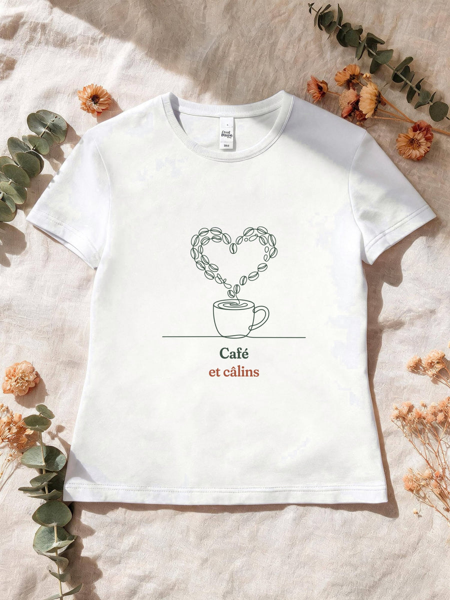Visuel d’illustration – T-shirt femme blanc avec le motif une tasse de café d’où s’échappe un cœur dessiné en grains de café et « Café et câlins »