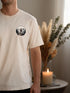 Homme portant un t-shirt randonnée blanc cassé petit motif poitrine