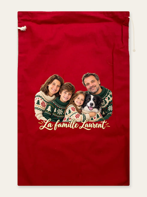 Visuel d’illustration – hotte de Noël en coton rouge cerise, 40 × 62 cm, à plat, vue de face, avec le portrait d’une famille de quatre et de son chien, style Noël douillet, texte « La famille Laurent » en lettres dorées