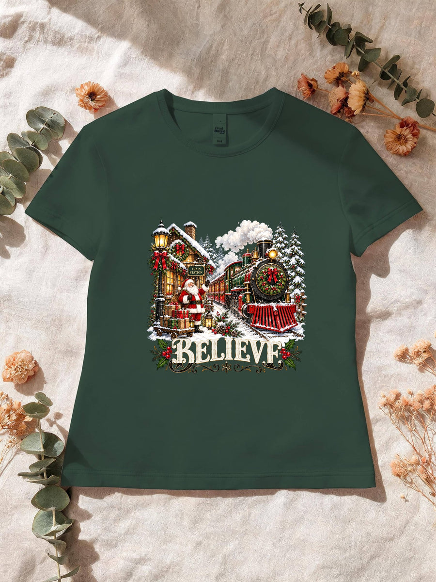 Visuel d’illustration – T-shirt femme vert forêt avec le Père Noël et le train à vapeur devant la gare enneigée, « Believe »