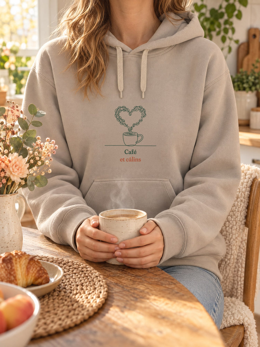 Visuel d’illustration – t-shirt dans une mise en situation, avec le motif une tasse de café d’où s’échappe un cœur dessiné en grains de café et « Café et câlins »