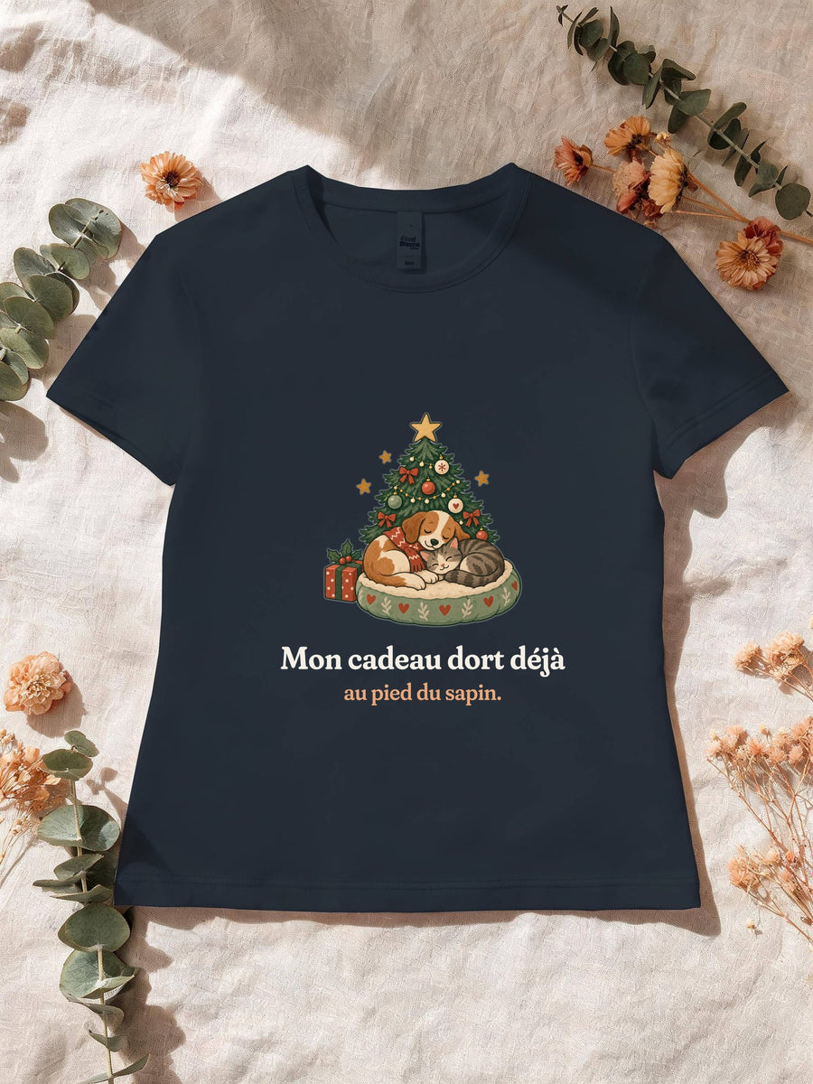 Visuel d’illustration – T-shirt femme navy avec le motif de Noël : un chien et un chat endormis au pied d’un petit sapin et la phrase « Mon cadeau dort déjà au pied du sapin. »