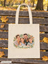 Visuel d’illustration – tote bag posé sur un banc en bois dans un parc en automne, avec un portrait de famille fictive en style Portrait signature, texte « Famille Laurent »
