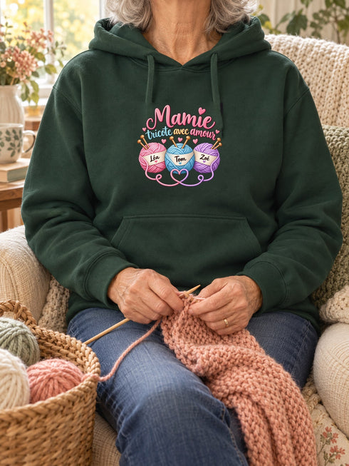 Visuel d’illustration – Grand-mère portant un sweat vert forêt personnalisé « Mamie tricote avec amour » avec les prénoms Léa, Tom et Zoé