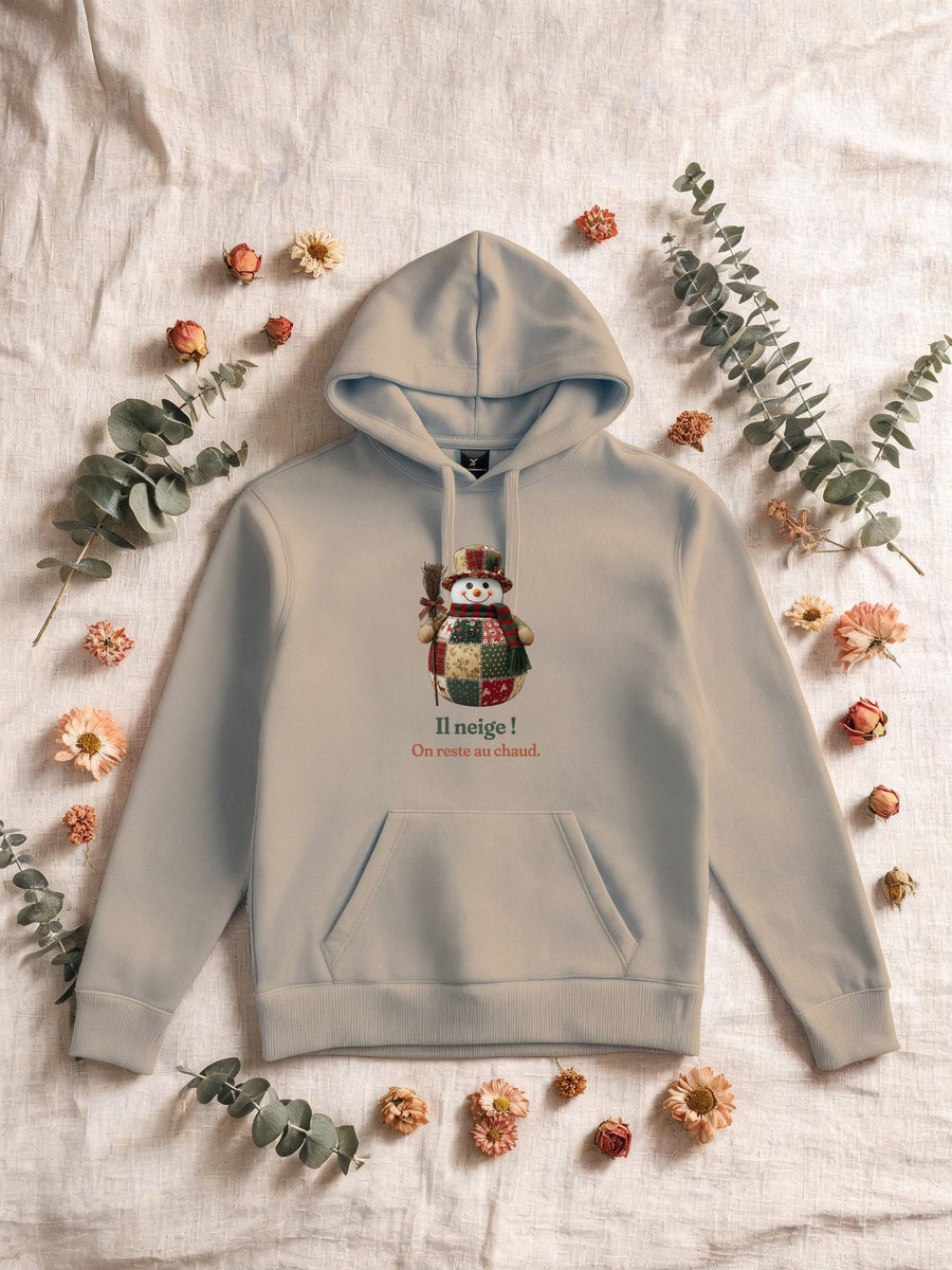 Visuel d’illustration – Sweat homme sable avec le motif un bonhomme de neige en patchwork et « Il neige ! » et « On reste au chaud. »