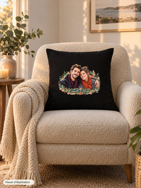 Visuel d’illustration – housse de coussin noire sur un fauteuil crème, avec un plaid, une bougie et de l’eucalyptus, avec un portrait de couple en style Portrait signature, prénoms « Camille & Hugo » en lettres claires
