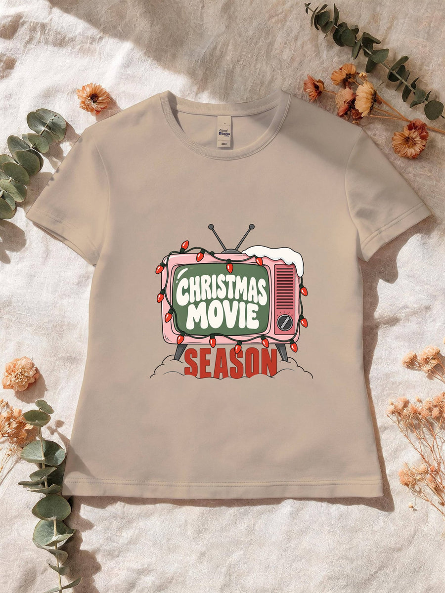 Visuel d’illustration – T-shirt femme sable avec la télé rétro rose et sa guirlande, « Christmas Movie Season »