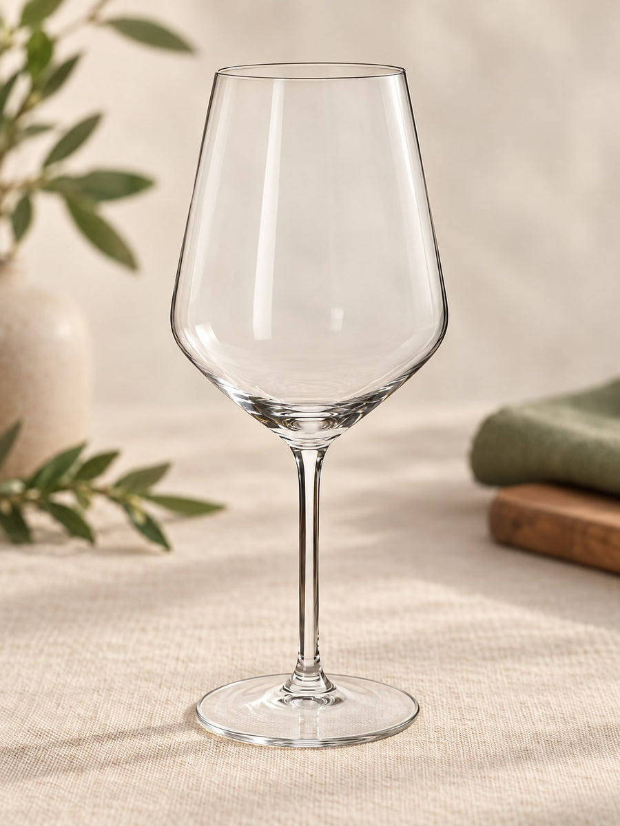 Visuel d’illustration – verre à vin rouge à pied en verre transparent vierge, sur un lin crème
