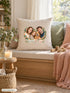 Visuel d’illustration – housse de coussin naturel sur une banquette de salon, avec un plaid, une bougie et des cubes en bois, avec le portrait à l’aquarelle d’une famille et de son chien, texte « Lou, Paul, Emma & Biscuit »