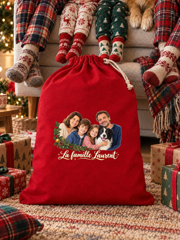 Visuel d’illustration – une hotte de Noël rouge remplie de cadeaux devant le canapé, le matin de Noël, avec le portrait d’une famille de quatre et de son chien, style Couronne de Noël, texte « La famille Laurent » en lettres dorées