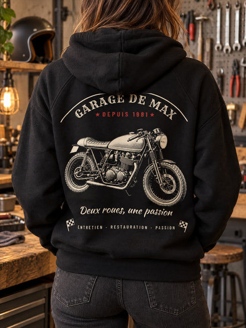 Visuel d’illustration : femme de dos dans un atelier, sweat noir avec le dessin Garage vintage d’une moto en grand dans le dos