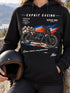 Visuel d’illustration : femme en sweat noir Affiche de course d’une moto, casque à la main, sur une route de montagne