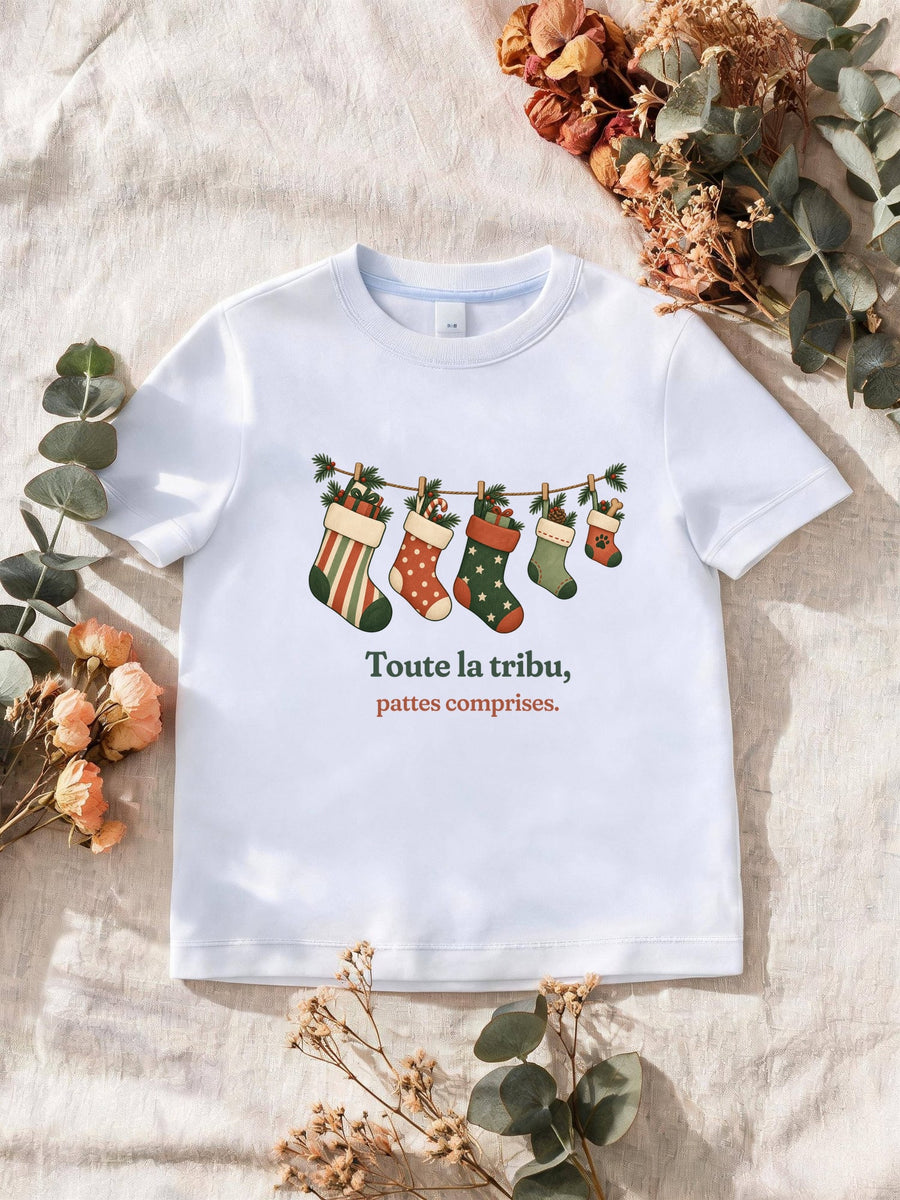 Visuel d’illustration – T-shirt homme blanc avec le motif de Noël : une guirlande de chaussettes de Noël, dont une petite avec une empreinte de patte, et la phrase « Toute la tribu, pattes comprises. »