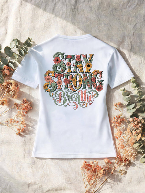 T-shirt femme blanc, lettering floral « Stay Strong Breathe » imprimé au dos, posé sur lin et eucalyptus