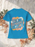 T-shirt femme Blue Atoll, motif fleuri rétro « There is sunshine in my soul » imprimé au dos, posé sur lin beige et fleurs séchées