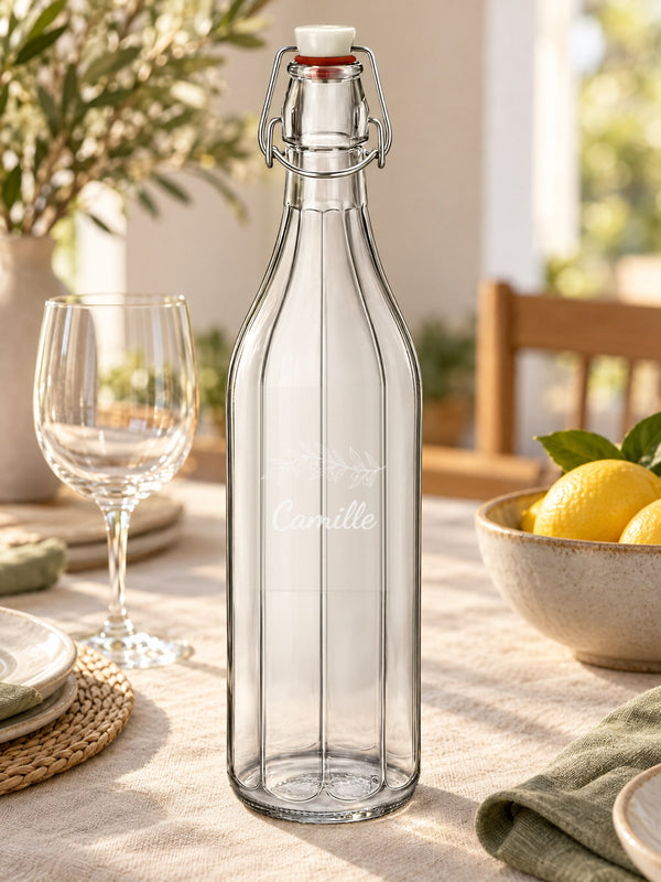 Visuel d’illustration – bouteille gravée d’un rameau d’olivier et « Camille » (exemple) sur une table dressée