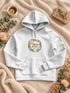 Visuel d’illustration – Sweat à capuche blanc avec le design « Maman d’amour », posé à plat sur un plaid, avec les prénoms d’exemple