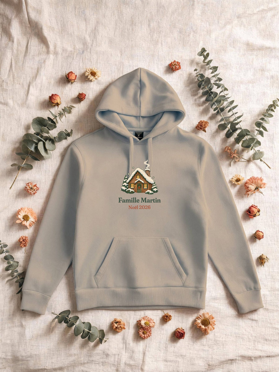 Visuel d’illustration – Sweat homme sable avec le motif un chalet sous la neige et « Famille Martin · Noël 2026 » (exemple de nom)