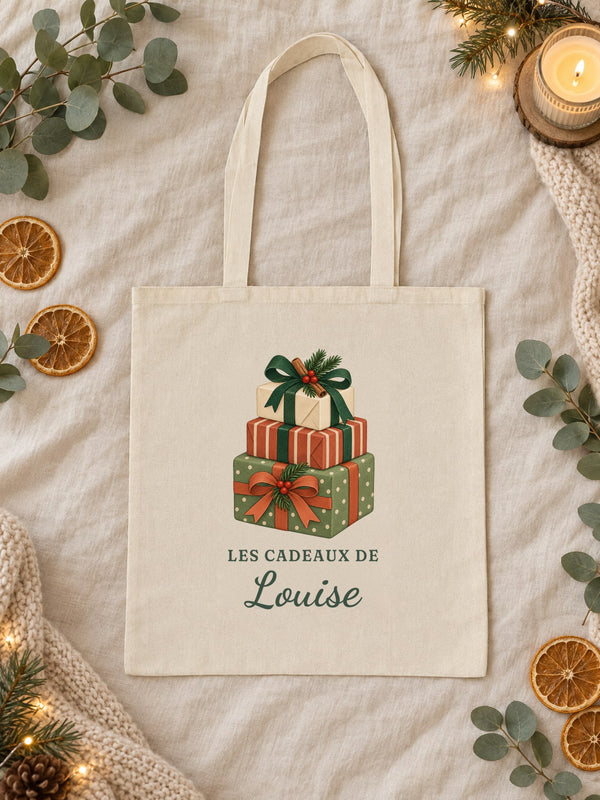 Visuel d’illustration – tote bag en coton naturel posé à plat, avec le motif : une pile de paquets cadeaux et « Les cadeaux de Louise » (exemple de prénom)