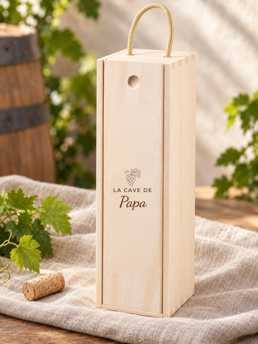 Visuel d’illustration – caisse à vin sur un lin près d’un bouchon et de feuilles de vigne, gravée « La cave de Papa » (exemple)