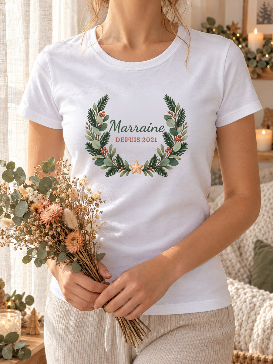 Visuel d’illustration – t-shirt blanc dans une mise en situation, avec le motif une couronne de sapin et « Marraine depuis 2021 » (exemple d’année)