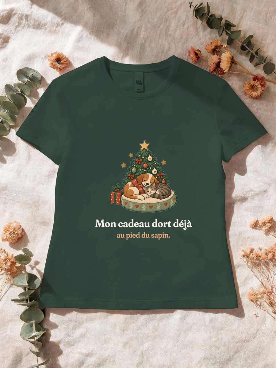 Visuel d’illustration – T-shirt femme vert forêt avec le motif de Noël : un chien et un chat endormis au pied d’un petit sapin et la phrase « Mon cadeau dort déjà au pied du sapin. »