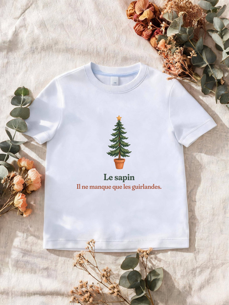 Visuel d’illustration – T-shirt homme blanc avec le motif un sapin nu en pot et « Le sapin. Il ne manque que les guirlandes. »