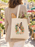 Visuel d’illustration – tote bag porté à l’épaule au marché, vu de dos, avec une baguette et des fleurs, avec le portrait à l’aquarelle d’Hector, chien fictif, et son prénom