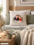Visuel d’illustration – housse de coussin naturel sur un lit, avec du linge de lit en lin, un plaid et une bougie, avec un portrait de couple à l’aquarelle, prénoms « Camille & Hugo »
