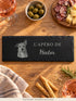 Planche apéro portrait en ardoise posée sur une table d'apéritif, entre olives, charcuterie et fromage