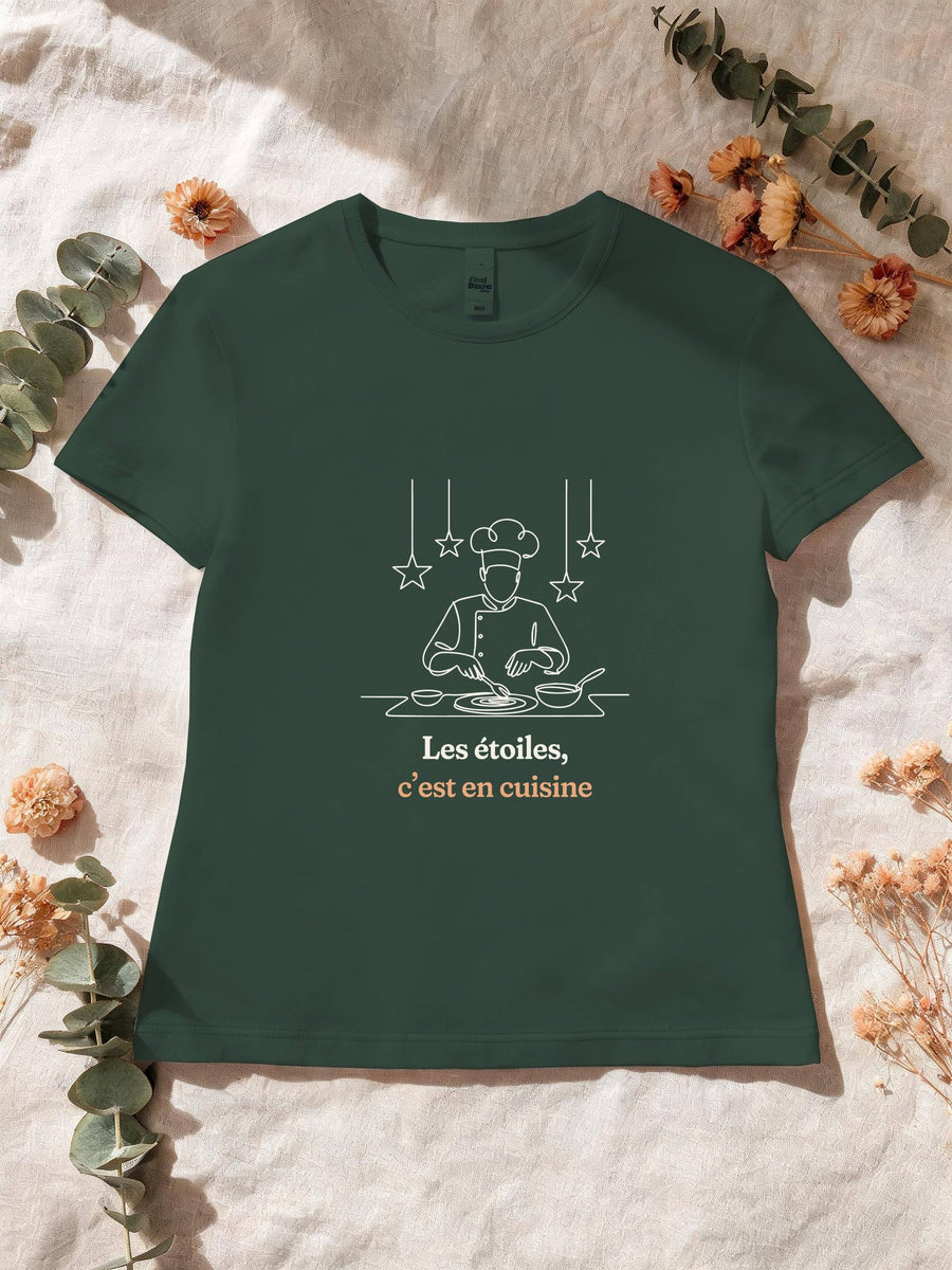 Visuel d’illustration – T-shirt femme vert forêt avec le motif un cuisinier en toque qui dresse une assiette sous des étoiles suspendues, dessiné d’un seul trait et « Les étoiles, c’est en cuisine »