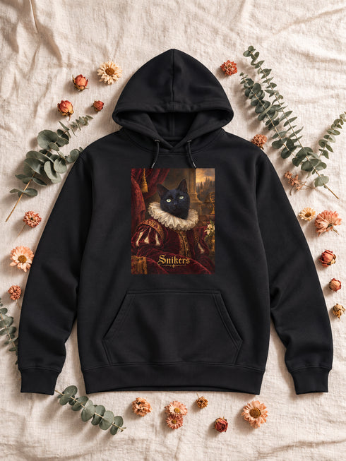 Sweat à capuche homme noir personnalisé avec le portrait Renaissance de Snikers, présenté à plat sur un décor en lin et fleurs séchées.