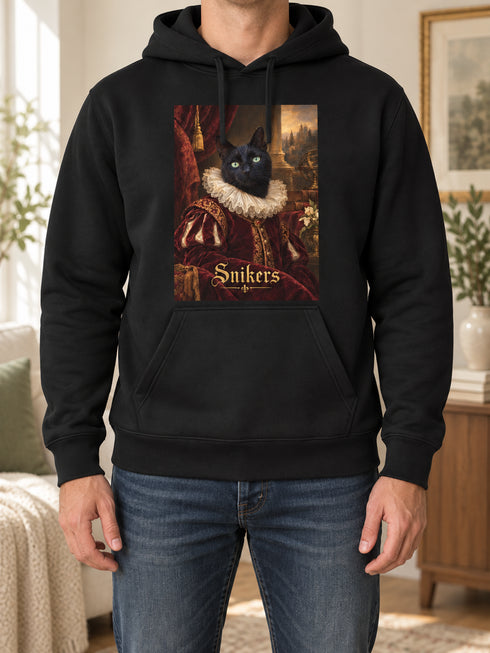 Homme portant un sweat noir personnalisé avec le portrait Renaissance de Snikers dans un intérieur chaleureux.