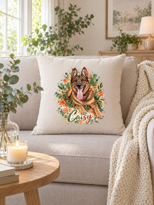 Visuel d’illustration – housse de coussin naturel sur un canapé, avec un plaid crème, une bougie et de l’eucalyptus, avec le portrait à l’aquarelle de Caisy, berger allemand, et son prénom