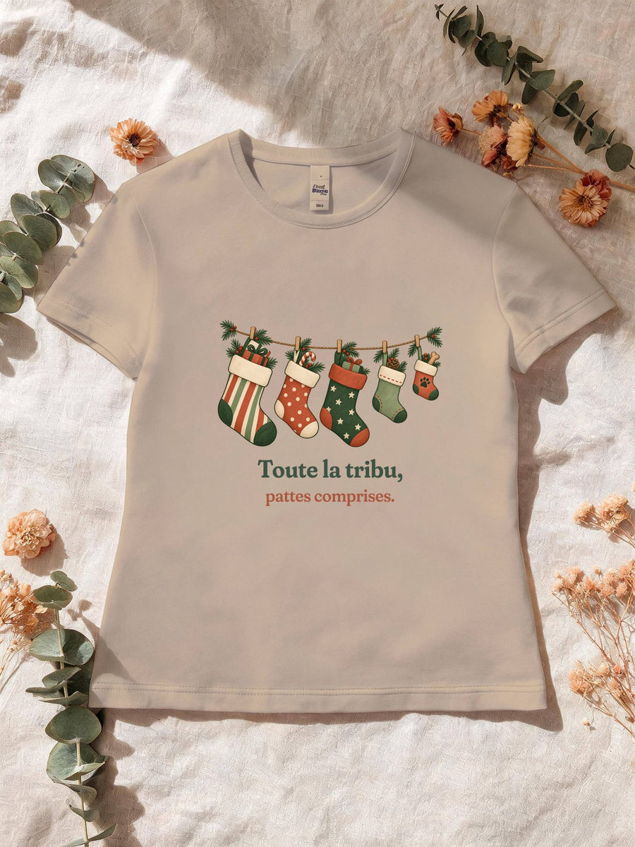 Visuel d’illustration – T-shirt femme sable avec le motif de Noël : une guirlande de chaussettes de Noël, dont une petite avec une empreinte de patte, et la phrase « Toute la tribu, pattes comprises. »