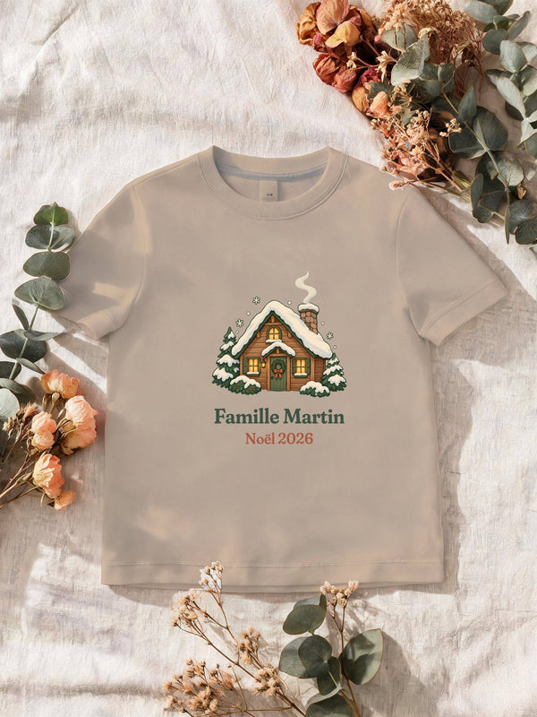 Visuel d’illustration – T-shirt homme sable avec le motif un chalet sous la neige et « Famille Martin · Noël 2026 » (exemple de nom)