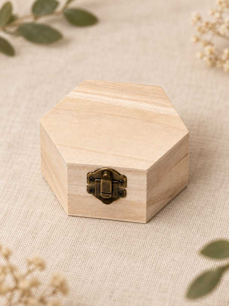 Visuel d’illustration – petit coffret hexagonal en bois clair vierge, fermé, sur un lin crème