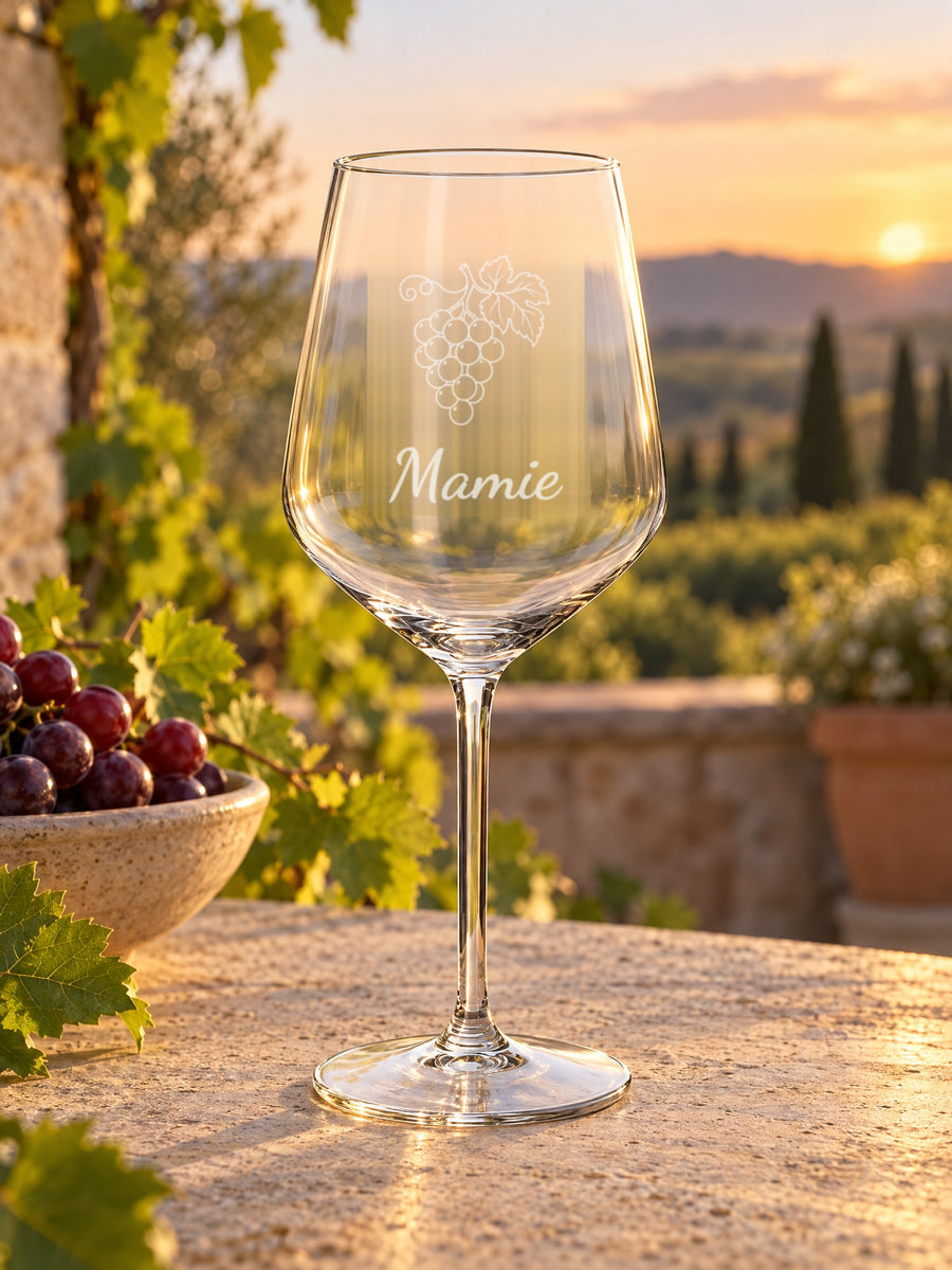 Visuel d’illustration – verre à vin sur une table de terrasse en pierre près de raisins, gravé « Mamie » (exemple)