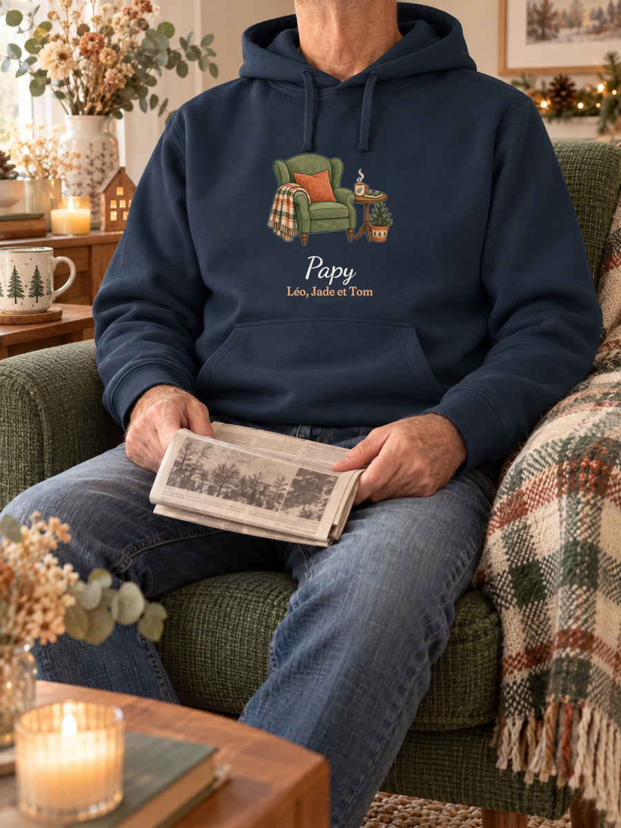Visuel d’illustration – sweat à capuche navy dans une mise en situation, avec le motif un fauteuil douillet, « Papy » et « Léo, Jade et Tom » (exemple de prénoms)