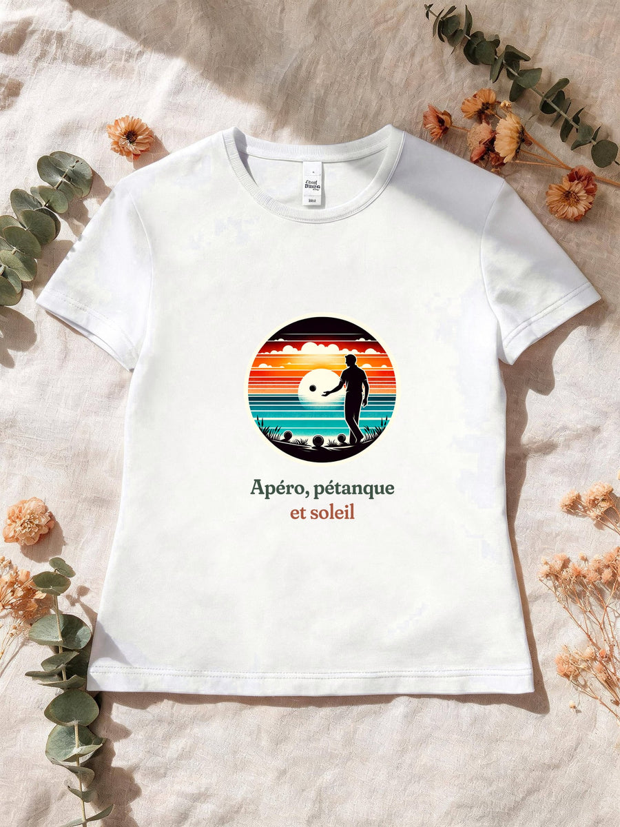 Visuel d’illustration – T-shirt femme blanc avec le motif un joueur de pétanque, boules au sol, en silhouette devant un coucher de soleil sur la mer, dans un médaillon rond et « Apéro, pétanque et soleil »