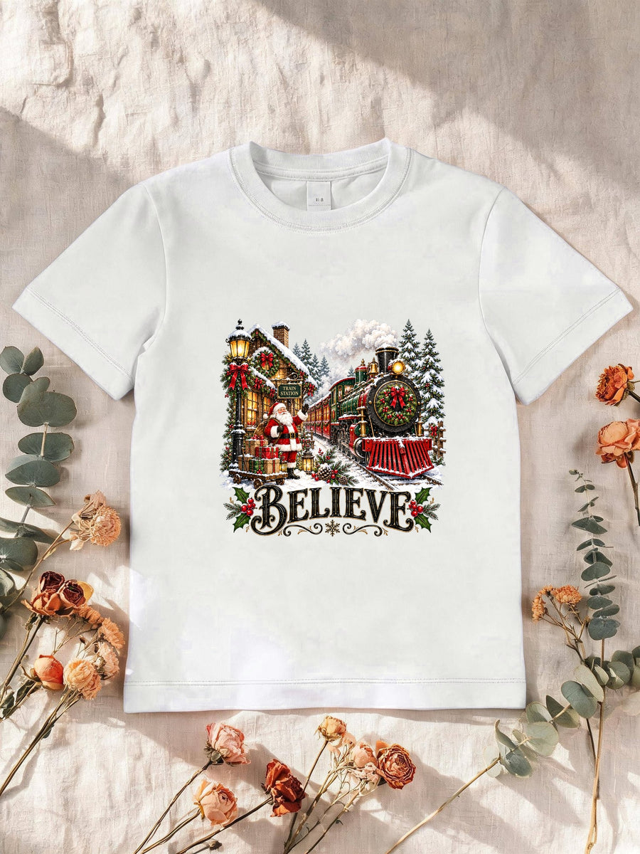 Visuel d’illustration – T-shirt enfant blanc avec le Père Noël et le train à vapeur devant la gare enneigée, « Believe »