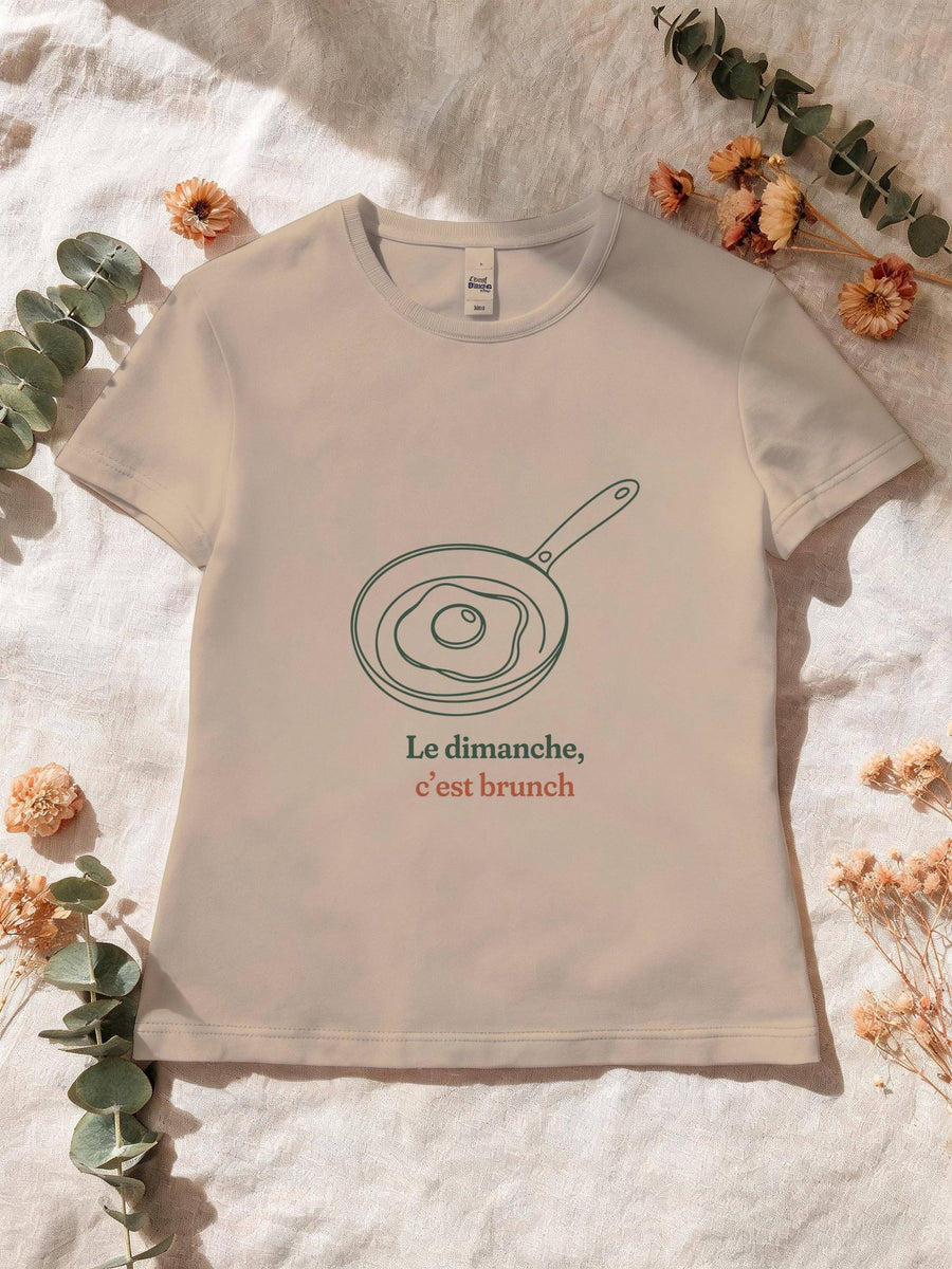 Visuel d’illustration – T-shirt femme sable avec le motif un œuf au plat dans une poêle, dessiné d’un seul trait continu et « Le dimanche, c’est brunch »