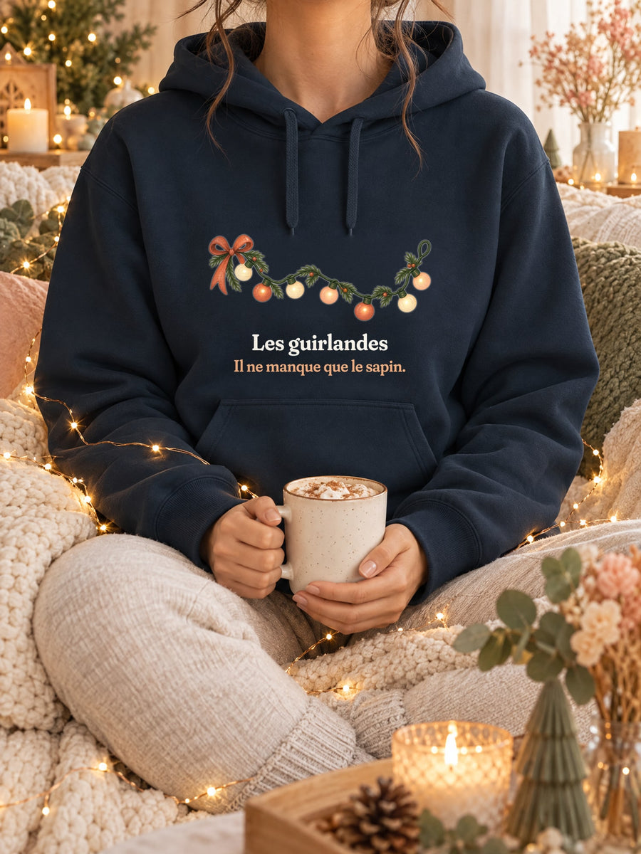 Visuel d’illustration – sweat à capuche navy dans une mise en situation, avec le motif une guirlande lumineuse et « Les guirlandes. Il ne manque que le sapin. »