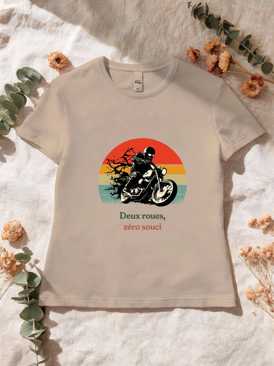 Visuel d’illustration – T-shirt femme sable avec le motif un motard casqué sur sa moto, en silhouette devant un soleil couchant à bandes rétro et « Deux roues, zéro souci »