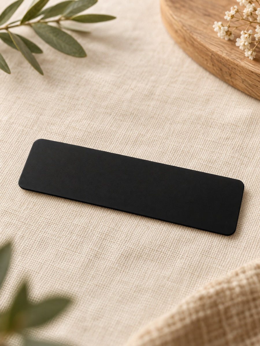 Visuel d’illustration – plaque en aluminium anodisé noir vierge de 8 × 2,5 cm, posée sur un lin crème