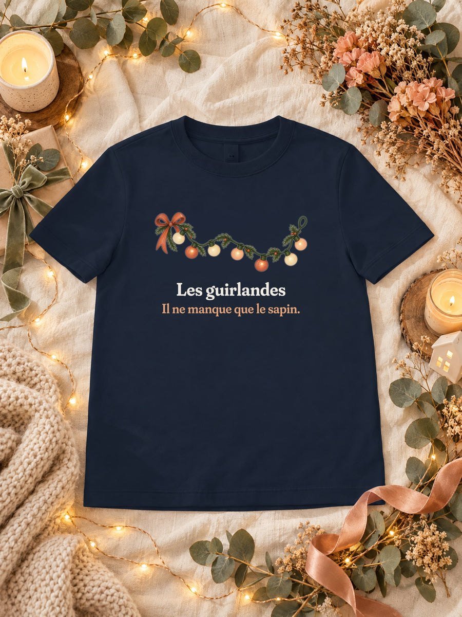 Visuel d’illustration – t-shirt navy dans une mise en situation, avec le motif une guirlande lumineuse et « Les guirlandes. Il ne manque que le sapin. »