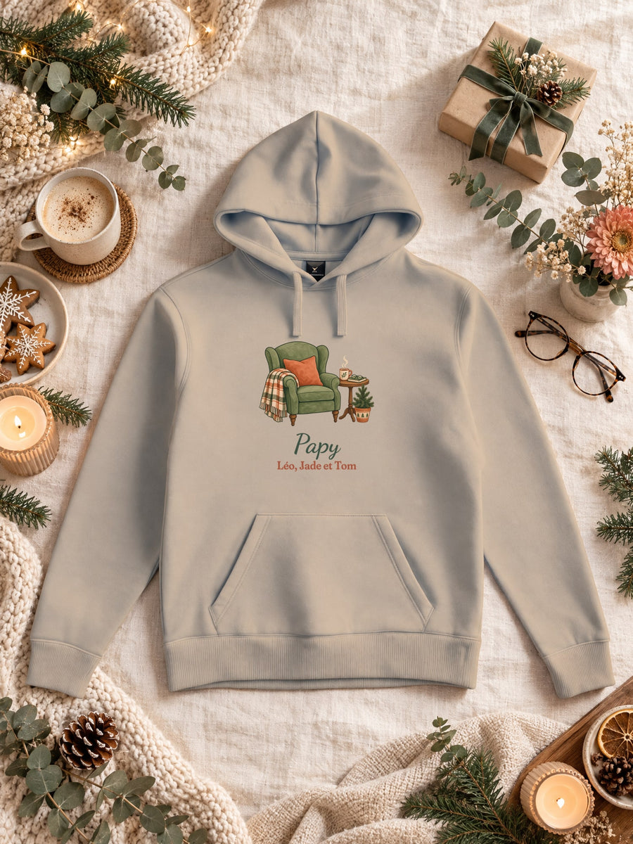 Visuel d’illustration – sweat à capuche sable dans une mise en situation, avec le motif un fauteuil douillet, « Papy » et « Léo, Jade et Tom » (exemple de prénoms)