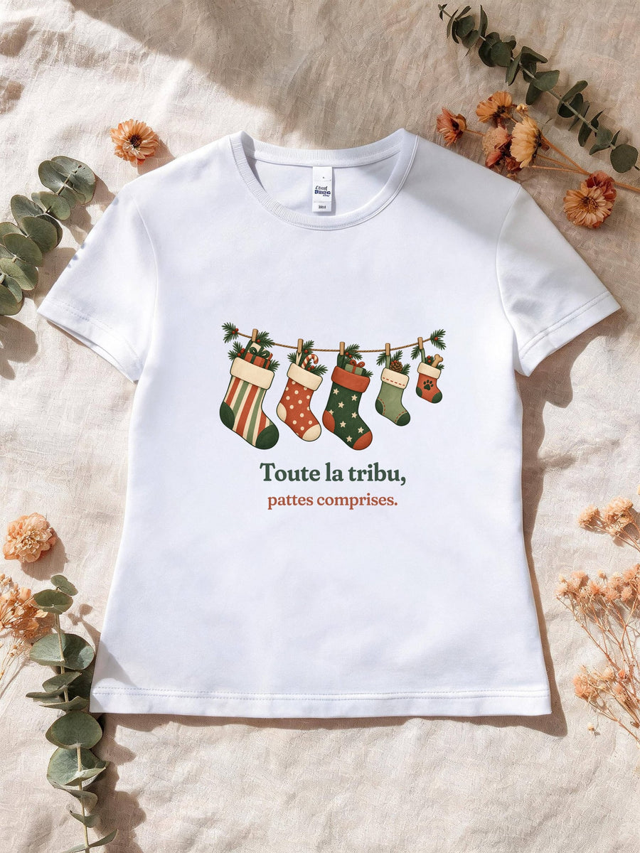 Visuel d’illustration – T-shirt femme blanc avec le motif de Noël : une guirlande de chaussettes de Noël, dont une petite avec une empreinte de patte, et la phrase « Toute la tribu, pattes comprises. »