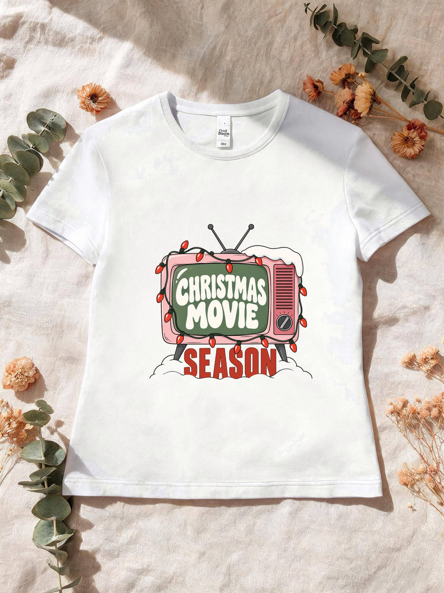 Visuel d’illustration – T-shirt femme blanc avec la télé rétro rose et sa guirlande, « Christmas Movie Season »