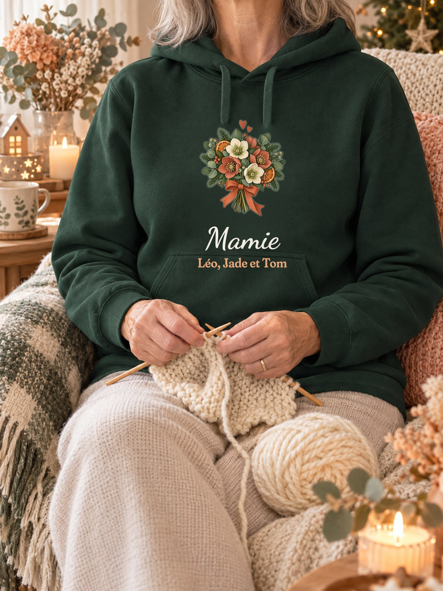 Visuel d’illustration – sweat à capuche vert forêt dans une mise en situation, avec le motif un bouquet d’hiver, « Mamie » et « Léo, Jade et Tom » (exemple de prénoms)